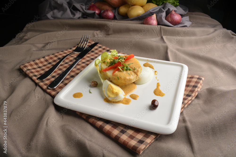 boiled egg with potato salad and dressing in square plate appetiser Peruvian cuisine menu boiled egg with potato salad and dressing in square plate appetiser Peruvian cuisine menu