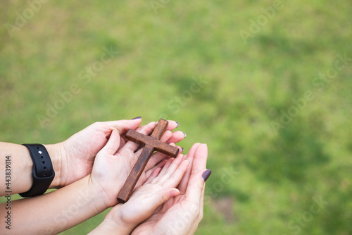 woman hands praying to god with wooden cross © sticker2you