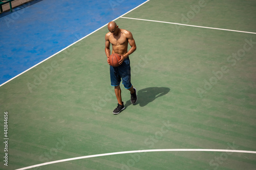 One african-american male basketball player playing at street public stadium, sport court or palyground outdoors. Concept of healthy active lifestyle, motion, hobby.