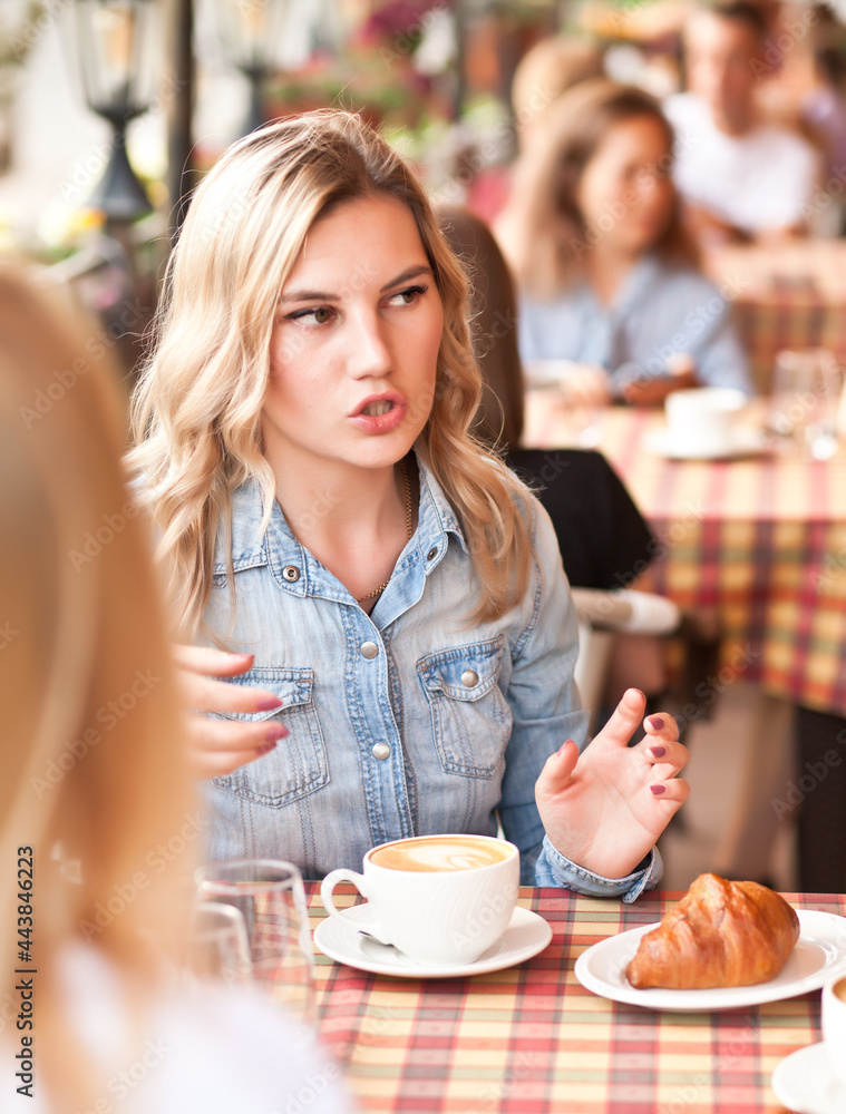 Women at cafe drinking coffee and talking. Communication and friendship concept. Women at cafe drinking coffee and talking. Communication and friendship concept.
