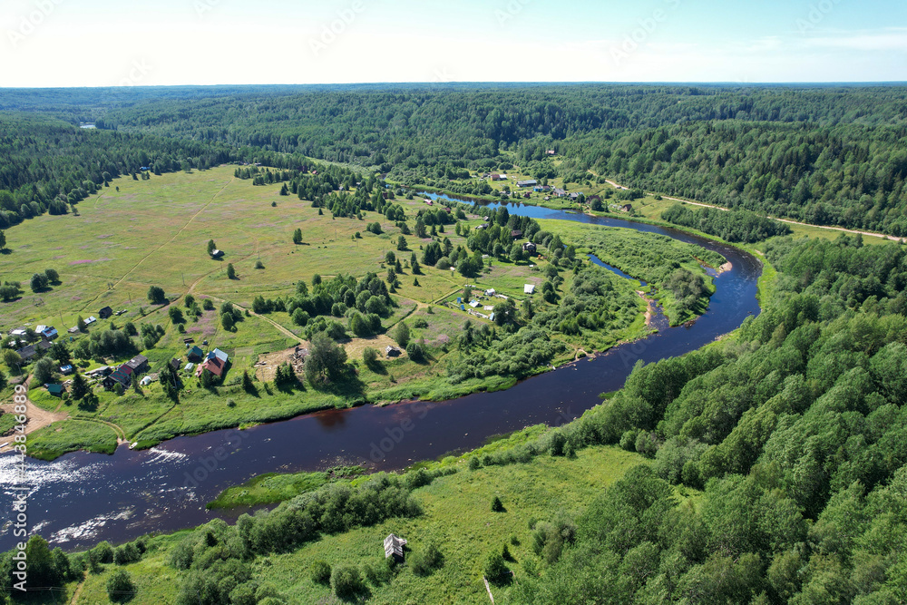 aerial view river flowing village by the river in the middle of the forest river bend houses and agricultural field