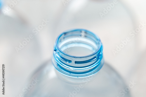 Transparent plastic bottles, on a clear surface. Transparent bottle neck. Recycling and disposal of single-use plastics. 