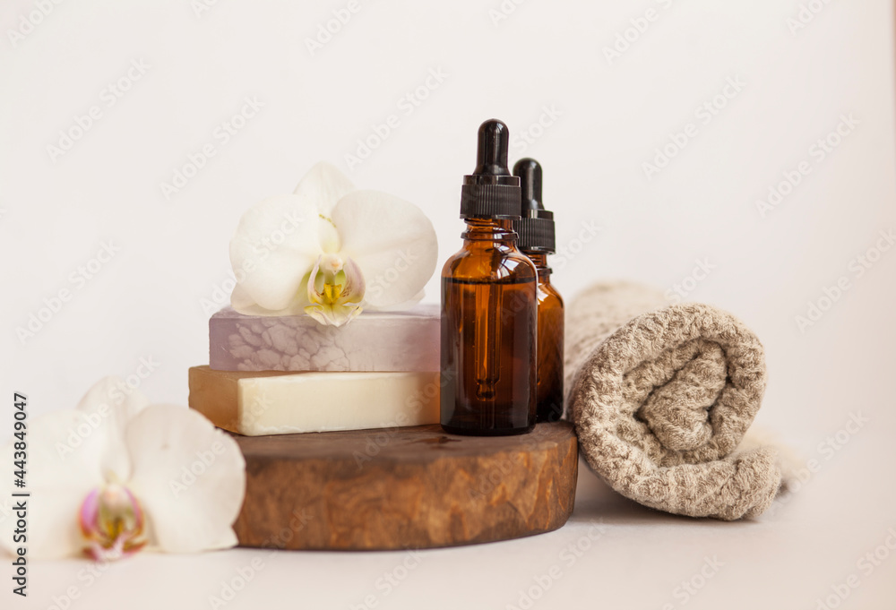 Concept of natural ingredients in cosmetology for skin care. Organic aroma oil in glass bottle, handmade soap bars. white background,close up Concept of natural ingredients in cosmetology for skin care. Organic aroma oil in glass bottle, handmade soap bars. white background,close up