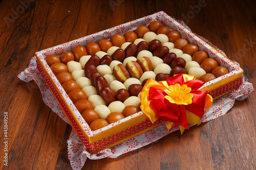 Indian sweets in a plate includes Gulab Jamun, Rasgulla, kaju katli, morichoor / Bundi Laddu, Gujiya or Karanji for diwali celebration photo