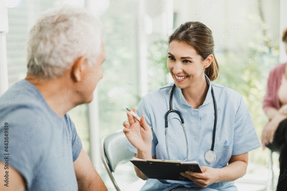 Senior Man Talking To Nurse At Waiting Room Senior Man Talking To Nurse At Waiting Room