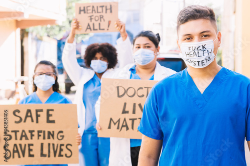Young Latin American or Hispanic male nurse wearing a mask, medical staff and medical students protest. health crisis concept. © Djavan Rodriguez