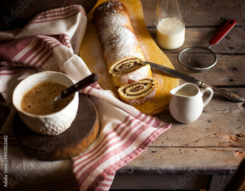 Tasty cake roll and coffee on old wooden table. Rustic style