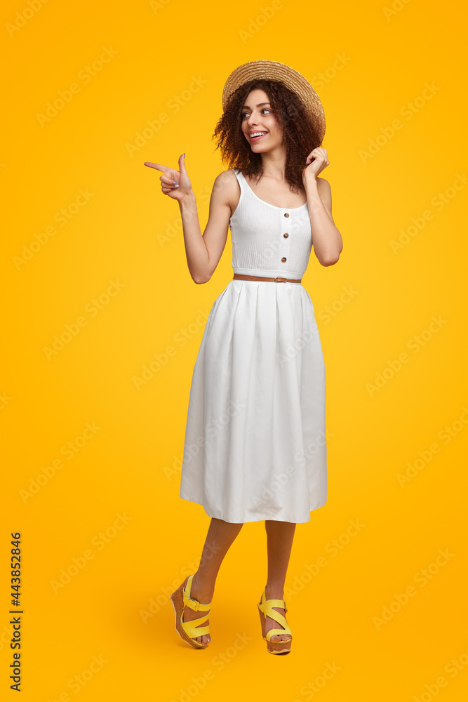 Stylish woman in summer outfit pointing away Stylish woman in summer outfit pointing away