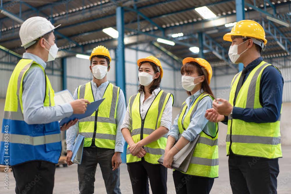 Group of Asian male and female engineers wearing hygienic mask protect with helmet safety in factory Industrial.Coronavirus Protective, safety concept Group of Asian male and female engineers wearing hygienic mask protect with helmet safety in factory Industrial.Coronavirus Protective, safety concept