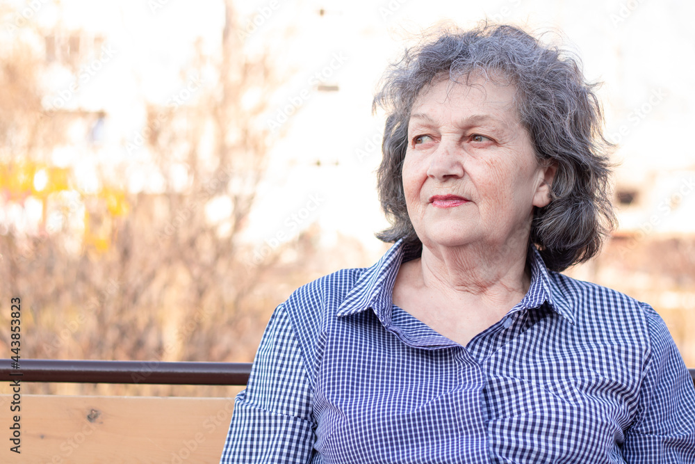 Street portrait of an elderly woman on the background of a European urban landscape, medium plan. Street portrait of an elderly woman on the background of a European urban landscape, medium plan.