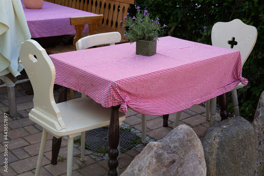 Fototapeta premium Rustic empty outdoor tables and chairs with tableclothes