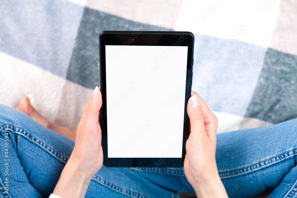 Female hands holds digital tablet with blank white desktop screen sitting at the home. Tablet blank screen mockup. Place for text. Close-up.