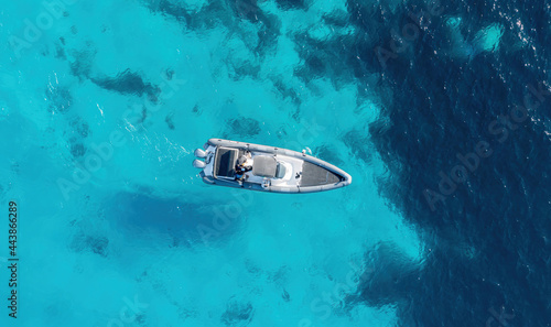 Aerial drone view of a speed boat on turquoise color sea water. Greece, Cyclades. . © Rawf8