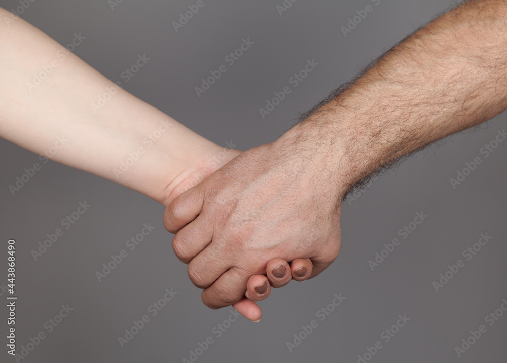 Hands of man and woman holding together, Gray background. Hands of man and woman holding together, Gray background.