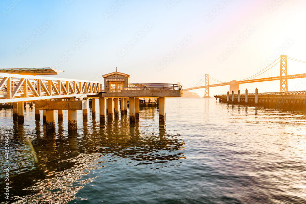 Incredible view of the pier and embankment in San Francisco at sunrise, the Oakland Bay Bridge is visible in the background Incredible view of the pier and embankment in San Francisco at sunrise, the Oakland Bay Bridge is visible in the background