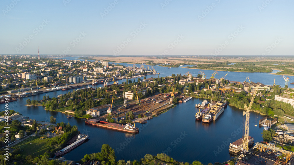 Aerial view of the Kherson city. The Dnieper River of which there are cranes and ships. Residential area with houses and greenery