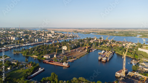 Aerial view of the Kherson city. The Dnieper River of which there are cranes and ships. Residential area with houses and greenery