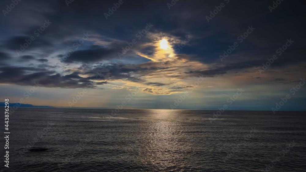 Sunset with dark clouds over Pacific ocean