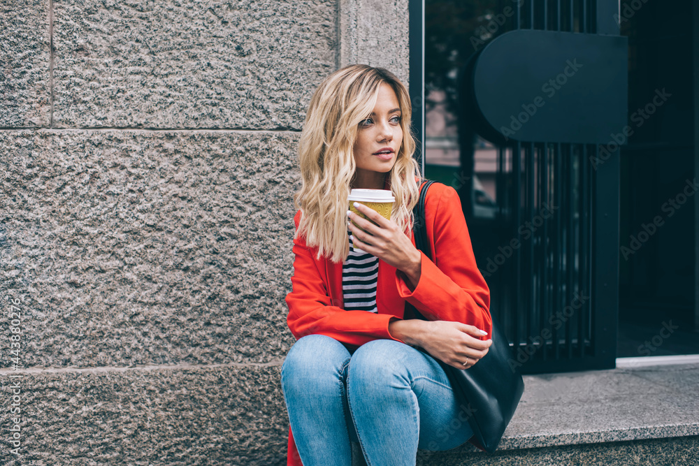 Pensive hipster girl with takeaway coffee to go spending travel daytime in city, Caucasian blonde tourist dressed in trendy jacket holding cup of caffeine beverage thinking about getaway vacations Pensive hipster girl with takeaway coffee to go spending travel daytime in city, Caucasian blonde tourist dressed in trendy jacket holding cup of caffeine beverage thinking about getaway vacations