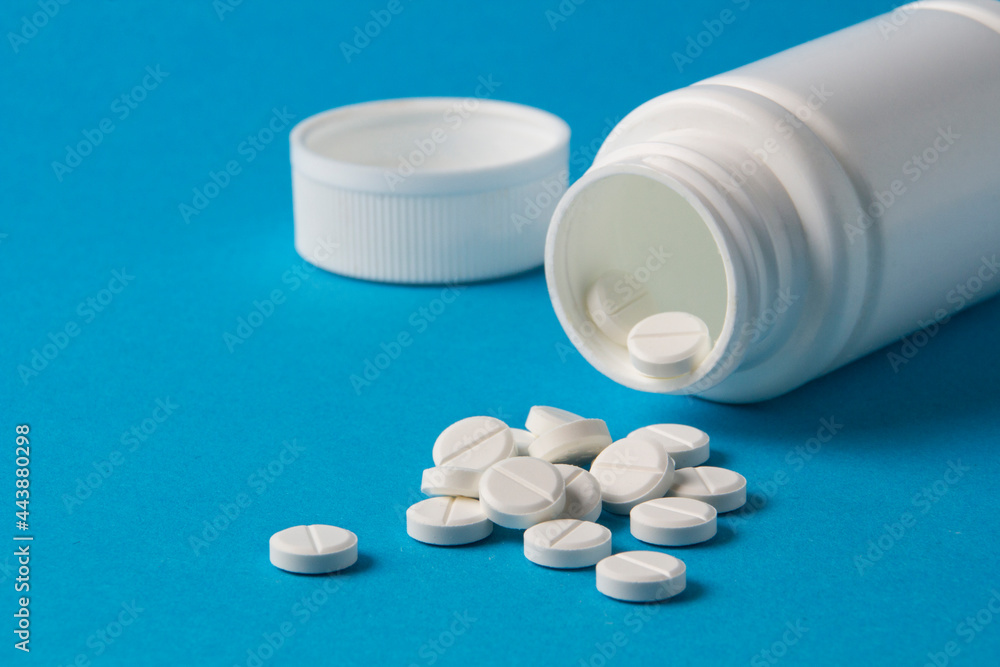 jar for pills and vitamins on a blue background jar for pills and vitamins on a blue background