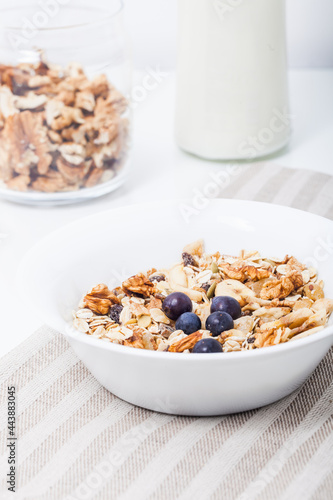 Homemade vegan granola cereal with soy yogurt, walnuts, blueberry and almond milk.