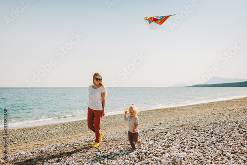 Mother and child walking on beach family travel vacations kite flying healthy lifestyle outdoor mom and daughter happiness freedom emotions enjoy life