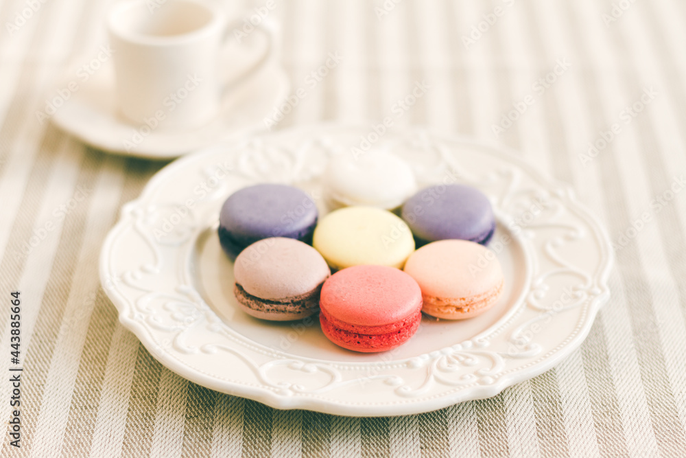 Different coloured macarons on white retro plate. Selective Focus Different coloured macarons on white retro plate. Selective Focus