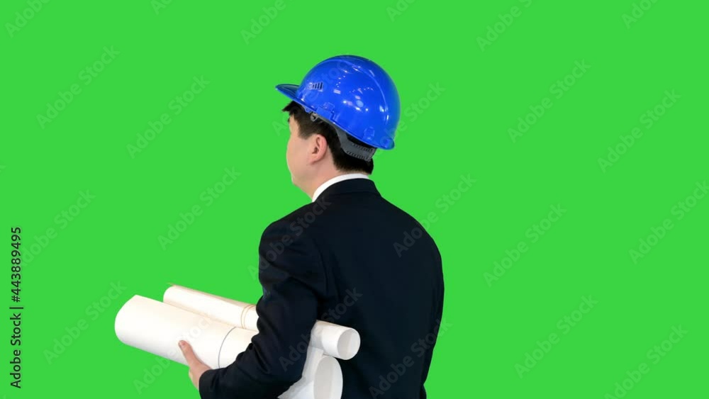 Young male architect walking with blueprints on a Green Screen, Chroma Key. Young male architect walking with blueprints on a Green Screen, Chroma Key.