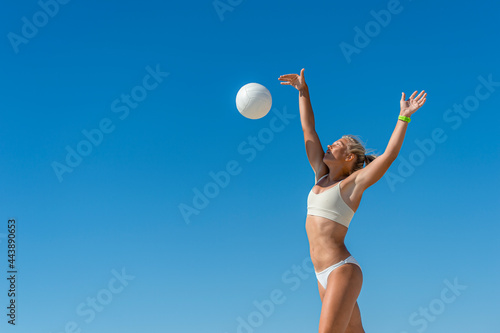 Young girl playing volleyball on the beach. Professional sport concept