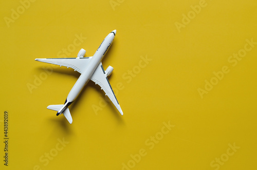 Top view of toy plane against yellow background