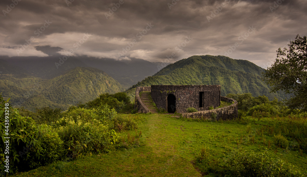 Rare circular stone building at the top of a mountain with green mountains at the background in a rain forest site in northern Argentina. Tucumán Province.