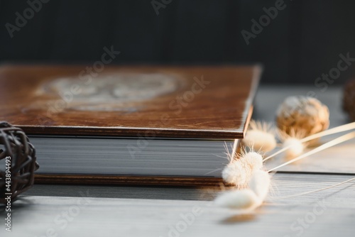 Family photo book with embossing. Photo book on a wooden background. Brown photo book with wood cover. Photoalbum with a hard cover. Wedding photo album.