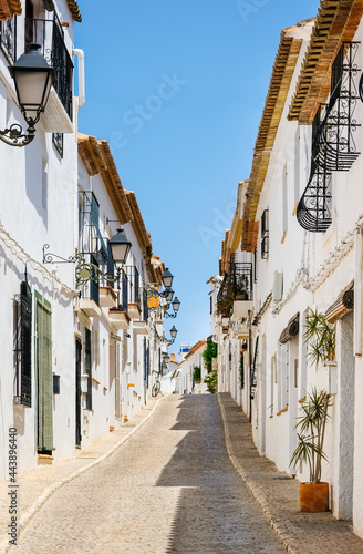 Typical view of Altea old town in Spain. Beautiful village with cobblestoned narrow streets, typical white houses and lanterns, popular tourist destination in Costa Blanca region. Vertical orientation
