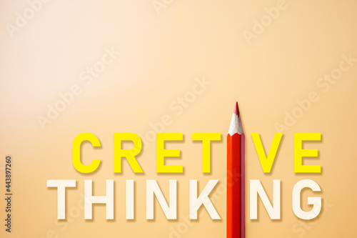 The creative thinking composition of the yellow and white typography interacts closely with the red pencil photo placed on orange paper with a minimalist -looking copy space. The concept of school.