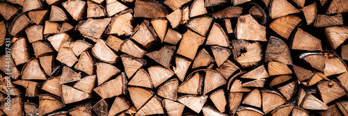textured firewood background of chopped wood for kindling and heating the house. a woodpile with stacked firewood. the texture of the birch tree. banner