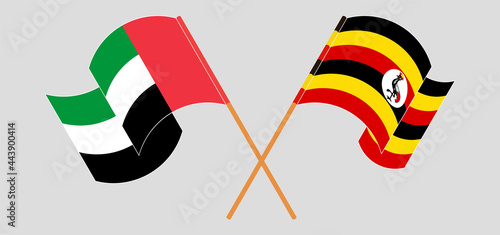 Crossed and waving flags of the United Arab Emirates and Uganda