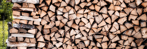a woodpile with harvesting and stacked firewood of chopped wood for kindling and heating the house. firewood of the birch tree. banner