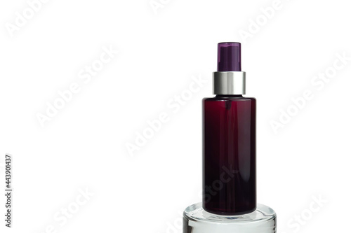 Unbranded brown plastic spray bottle on glass podium isolated on white background with clipping path. Cosmetic packaging mockup with copy space. Minimalism. Front view