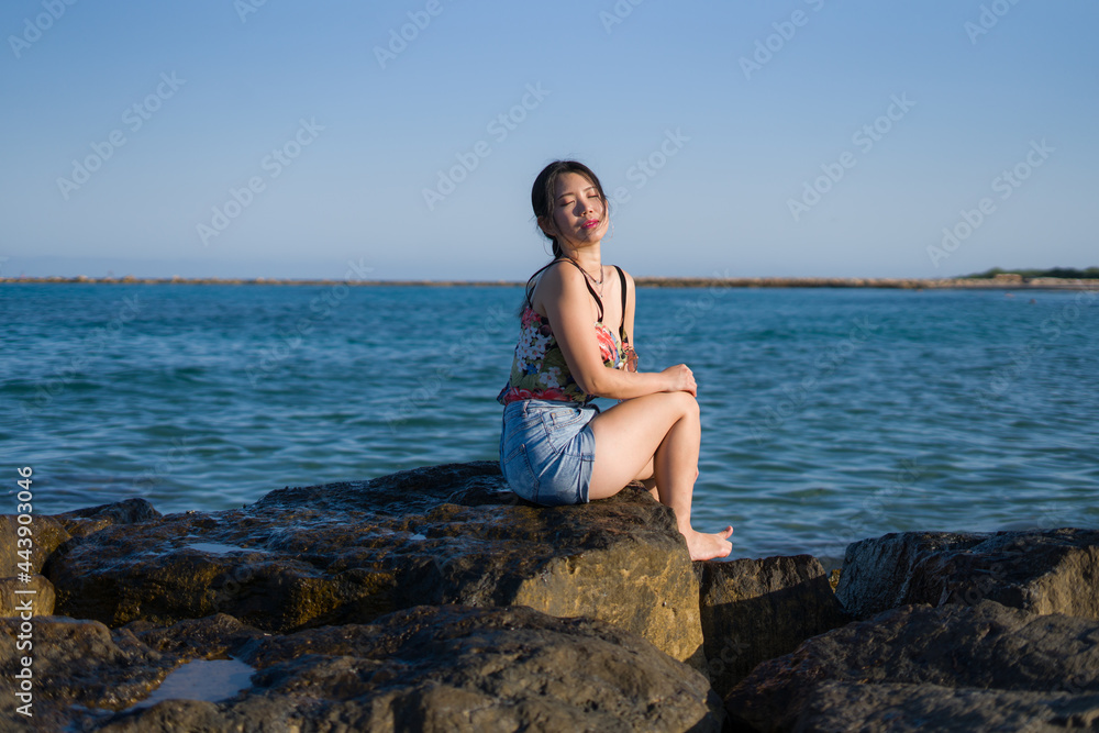 holidays lifestyle portrait of young Asian woman by the sea - happy and beautiful Korean girl enjoying beach vacation trip relaxed and cheerful at beach rock cliff holidays lifestyle portrait of young Asian woman by the sea - happy and beautiful Korean girl enjoying beach vacation trip relaxed and cheerful at beach rock cliff