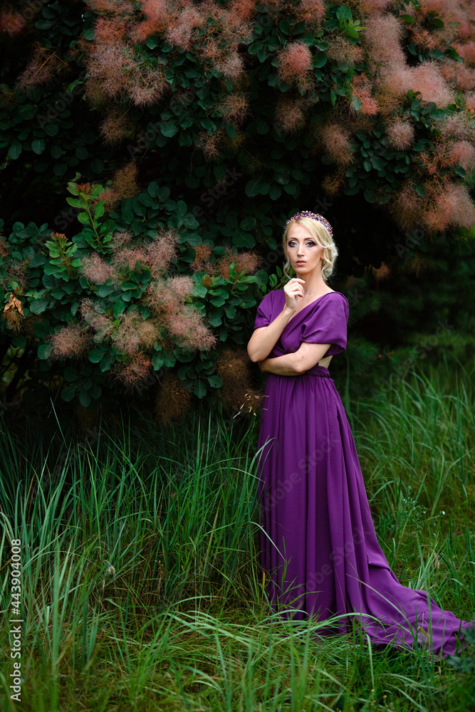 Girl model blonde in a lilac dress with a bouquet