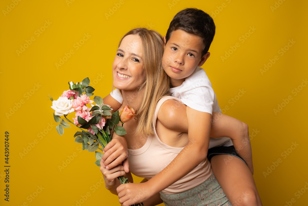 Son hugging happy mother with flowers. Mother`s day concept. Family holiday Son hugging happy mother with flowers. Mother`s day concept. Family holiday