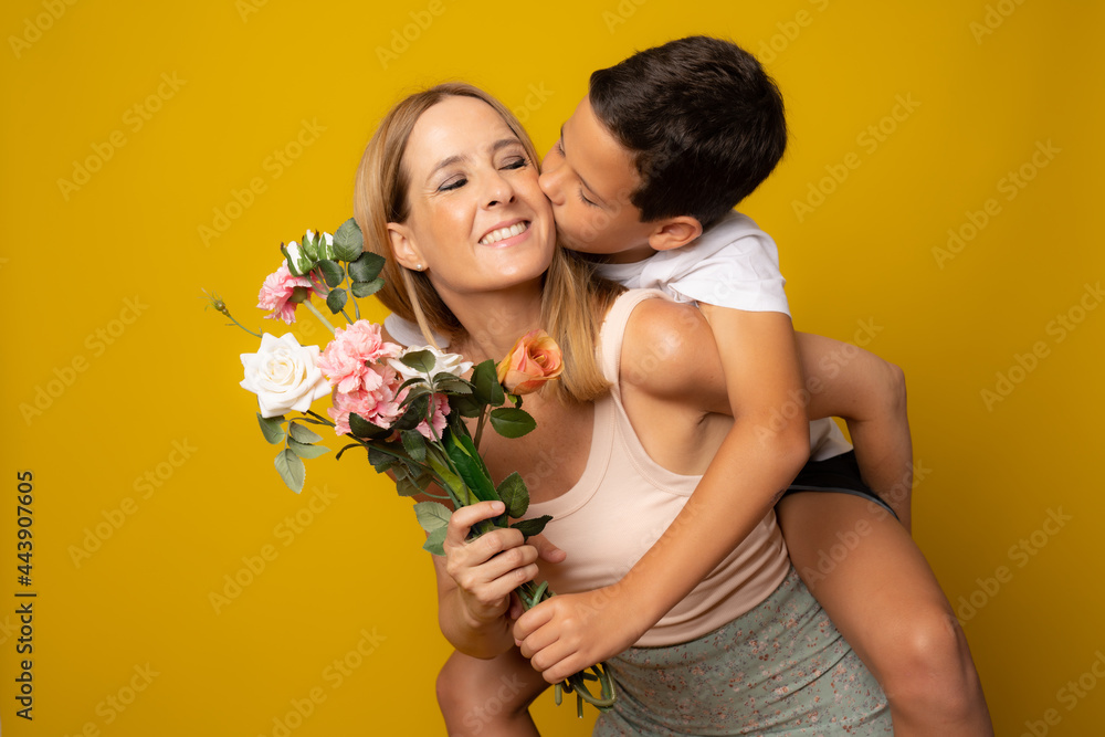 Son hugging happy mother with flowers. Mother`s day concept. Family holiday Son hugging happy mother with flowers. Mother`s day concept. Family holiday