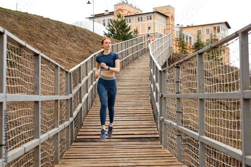 Foto Fit caucasian male in sportswear jobbing in bridge in countryside alone