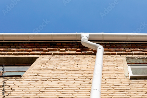 Εκτύπωση καμβά White metal pipe from the drain on the wall of a brick building