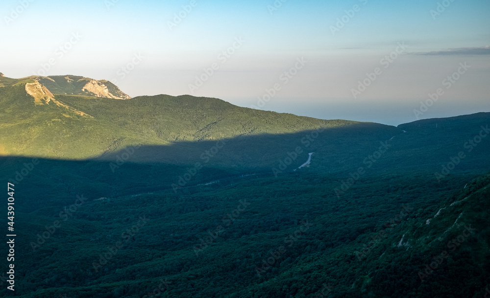 Pid to the surrounding mountains from the lower plateau of Chatyr-Dag in Crimea in the light of the setting sun.