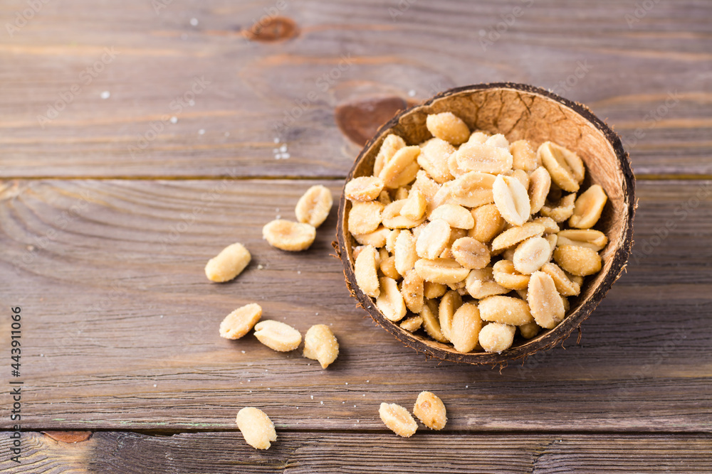 Salted peanuts in a bowl on a wooden table. Healthy vegetarian food. Rustic style Salted peanuts in a bowl on a wooden table. Healthy vegetarian food. Rustic style
