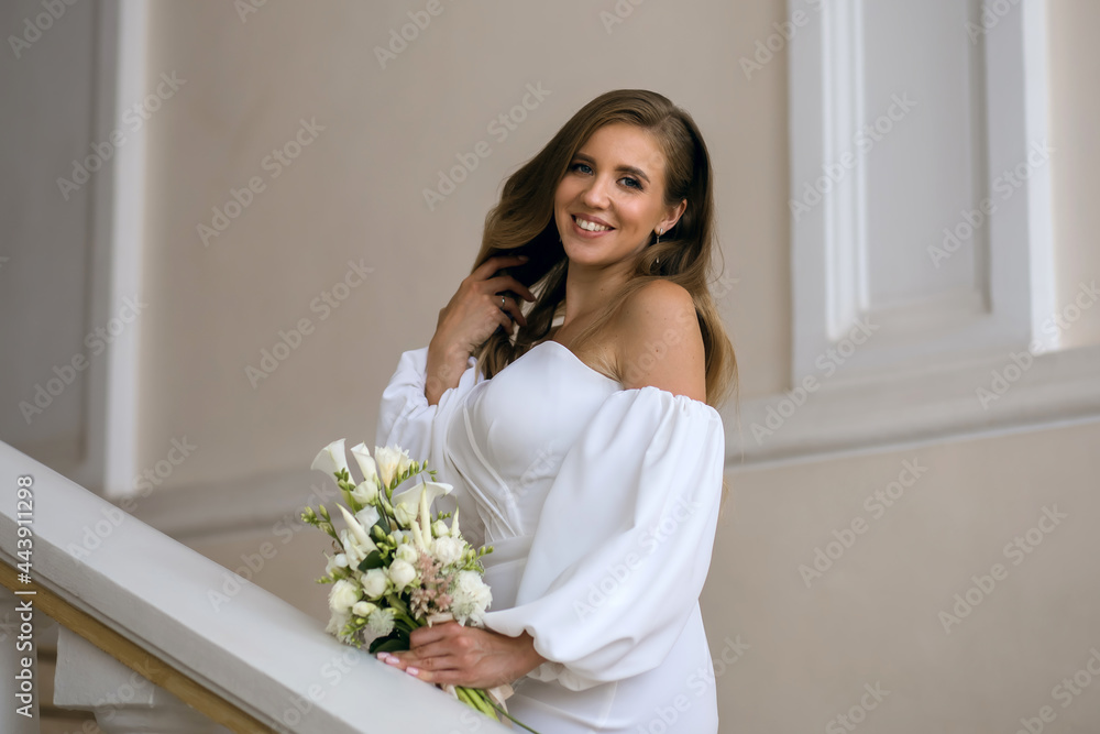 Beautiful cheerful bride in a white wedding dress holding a bouquet of white flowers. A young woman is getting married. Portrait of a chic bride with elegant hairstyle and makeup Beautiful cheerful bride in a white wedding dress holding a bouquet of white flowers. A young woman is getting married. Portrait of a chic bride with elegant hairstyle and makeup