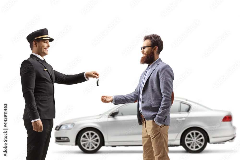 Chauffeur giving car keys from a silver car to a bearded man Chauffeur giving car keys from a silver car to a bearded man