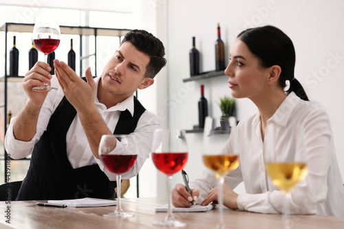 Papier peint Sommeliers tasting different sorts of wine at table indoors