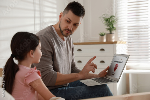 Photography Dad installing parental control on laptop at home. Child safety